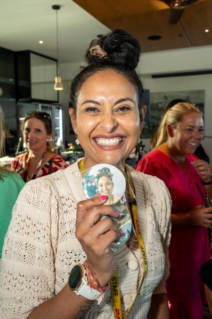 Smiling woman holds cookie bearing her image